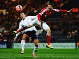 Lee Holmes (L) of Preston North End and Jamie Mackie (R) of Nottingham Forest challenge for the ball during the FA Cup Fourth Round Replay match on February 5, 2014