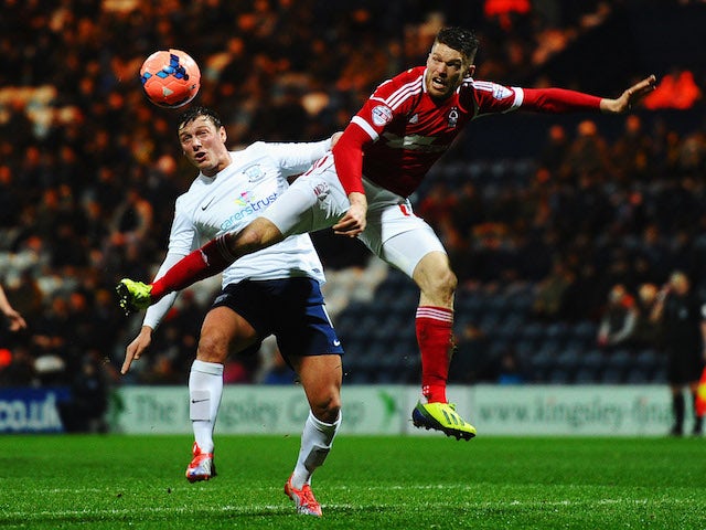 Lee Holmes (L) of Preston North End and Jamie Mackie (R) of Nottingham Forest challenge for the ball during the FA Cup Fourth Round Replay match on February 5, 2014