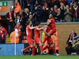 Liverpool's English midfielder Raheem Sterling celebrates with teammates after scoring their third goal during the English Premier League football match between Liverpool and Arsenal at Anfield in Liverpool, northwest England, on February 8, 2014