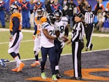 Running back Marshawn Lynch #24 of the Seattle Seahawks hands ball over after scoring a one yard touchdown against the Denver Broncos on February 2, 2014