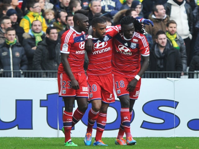 's French forward Alexandre Lacazette is congradulated by Lyon's French defender Samuel Umtiti and Lyon's French forward Bafetimbi Gomis during the French L1 football match between Nantes and Lyon on February 9, 2014