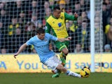 Martin Olsson of Norwich City tackled by James Milner of Manchester City during the Barclays Premier League match between Norwich City and Manchester City at Carrow Road on February 8, 2014