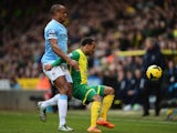 Nathan Redmond of Norwich City holds off the challenge of Vincent Kompany of Manchester City during the Barclays Premier League match between Norwich City and Manchester City at Carrow Road on February 8, 2014