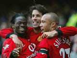 Man United's Ruud Van Nistelrooy celebrates with teammates Luis Saha and Mikael Silvestre after scoring his team's second goal against Everton on February 7, 2004