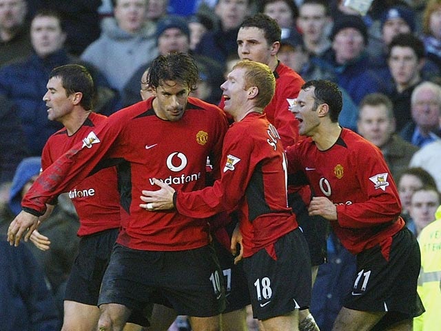 Man United's Ruud Van Nistelrooy celebrates with teammates after scoring his team's fourth goal against Everton during their Premier League match on February 7, 2004