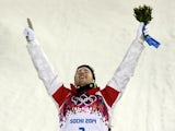 Canada's gold medallist Alex Bilodeau celebrates on the podium during the flower ceremony for the Men's Freestyle Skiing Moguls final at the Rosa Khutor Extreme Park on February 10, 2014
