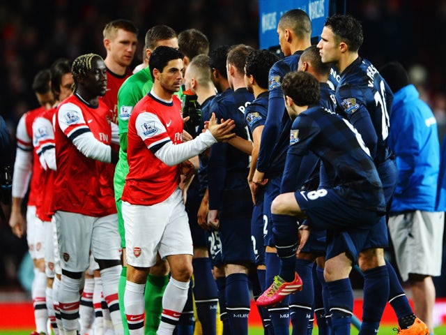 The two teams exchange handshakes before the Barclays Premier League match between Arsenal and Manchester United at the Emirates Stadium on February 12, 2014