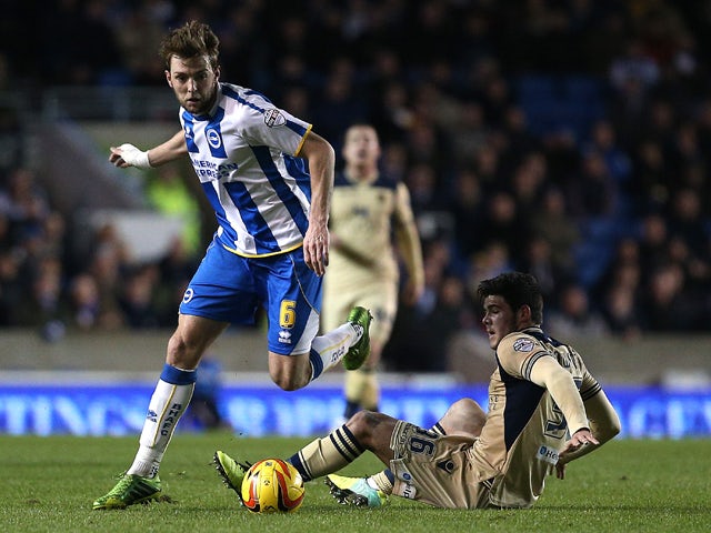 Dale Stephens of Brighton skips the tackle from Leeds' Alex Mowatt during the Sky Bet Championship match between Brighton & Hove Albion and Leeds United at The Amex Stadium on Febuary 11, 2014