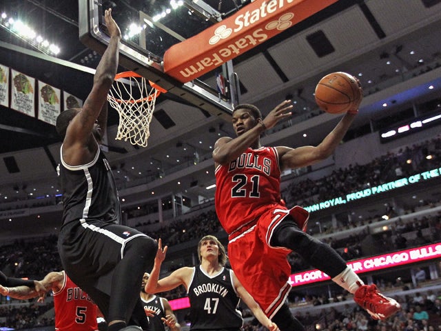 Jimmy Butler #21 of the Chicago Bulls leaps to pass around Andray Blatche #0 of the Brooklyn Nets at the United Center on February 13, 2014