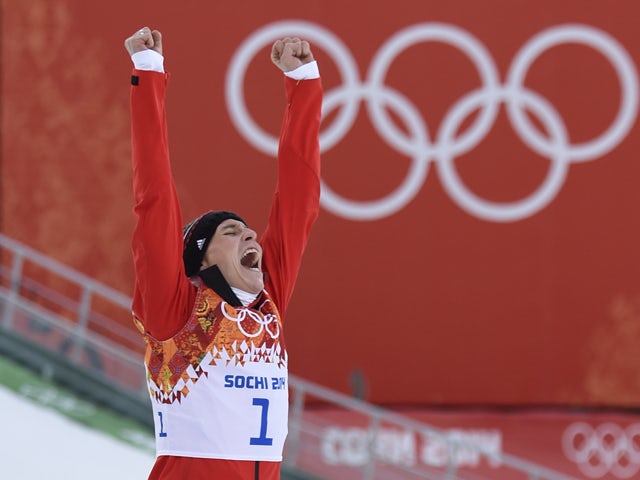 Gold medalist Germany's Eric Frenzel punches the air as he celebrates during the Nordic Combined Individual NH / 10 km Flower Ceremony at the RusSki Gorki Jumping Center during the Sochi Winter Olympics on February 12, 2014