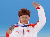 China's silver medalist Han Tianyu posing on the podium during the Men's Short Track 1500 m Medal Ceremony at the Sochi medals plaza on February 10, 2014