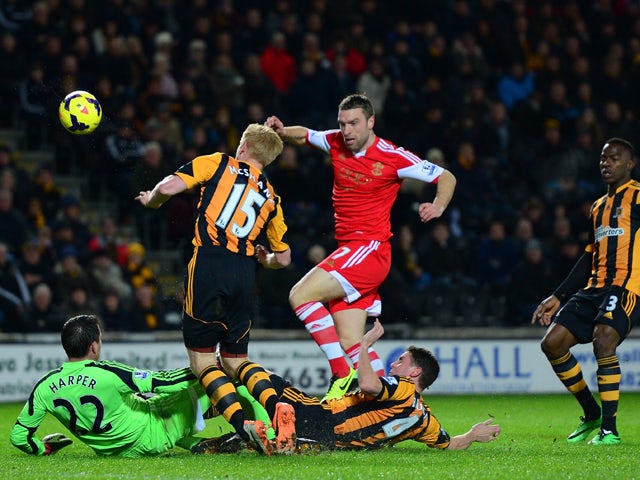 Rickie Lambert of Southampton is closed down by Steve Harper, Paul McShane and Alex Bruce of Hull City during the Barclays Premier League match between Hull City and Southampton at the KC Stadium on February 11, 2014