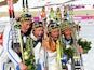 Gold medalists Ida Ingemarsdotter, Emma Wiken, Anna Haag and Charlotte Kalla of Sweden celebrate during the flower ceremony for the Women's 4 x 5 km Relay in Sochi on February 15, 2014