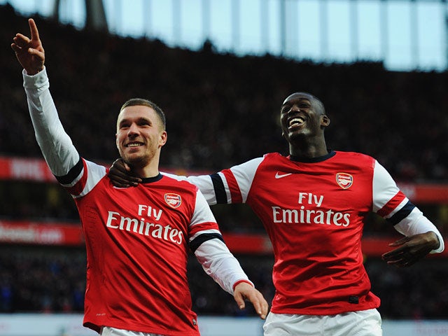 Arsenal's Lukas Podolski celebrates scoring with team mate Yaya Sanogo against Liverpool during their FA Cup fifth round match on February 9, 2014