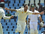 Australia cricketer Mitchell Johnson celebrates with team-mates after taking a wicket of South Africa's Alviro Petersen, during the 4th day of the first test match on February 15, 2014