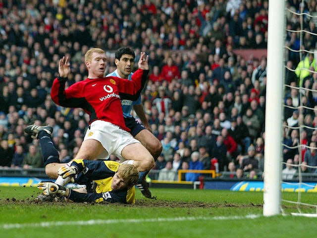 Paul Scholes scores the first goal for his team past Manchester City's goalkeeper Ari Arason on February 14, 2004