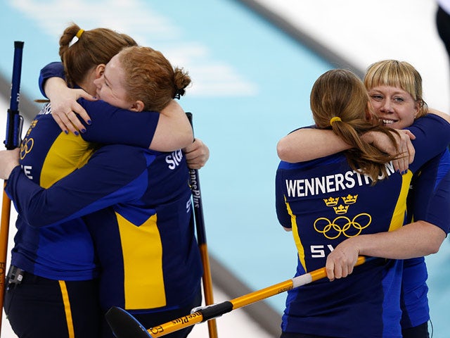 Sweden's women's curling team celebrate after winning the round robin session 10 match against Russia at the Ice Cube curling centre in Sochi on February 16, 2014
