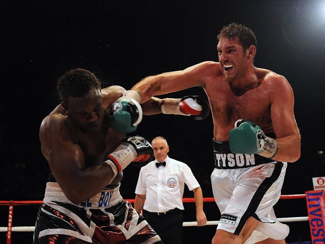 Tyson Fury throws a punch at Dereck Chisora during the British & Commonwealth Heavyweight Title Fight between Dereck Chisora and Tyson Fury at Wembley Arena on July 23, 2011