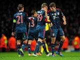 Thomas Muller of Bayern Munchen celebrates with Toni Kroos and Philipp Lahm of Bayern Munchen after scoring the second goal during the UEFA Champions League Round of 16 first leg match between Arsenal and FC Bayern Munchen at Emirates Stadium on February 