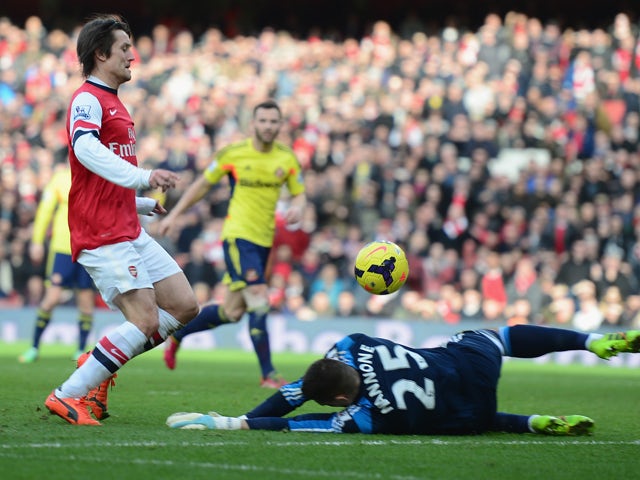 Tomas Rosicky of Arsenal lifts the ball over Vito Mannone of Sunderland to score a goal during the Barclays Premier League match between Arsenal and Sunderland at Emirates Stadium on February 22, 2014