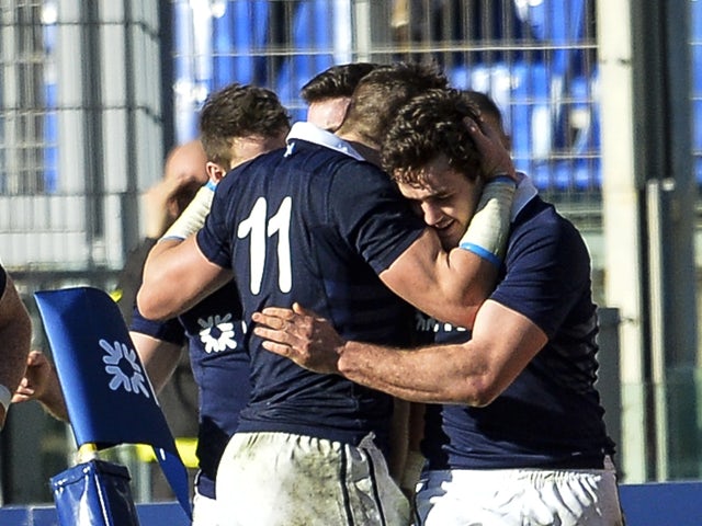 Scotland's Alex Dunbar celebrates with teammates after scoring a try during the Six Nations International rugby union match between Italy and Scotland on February 22, 2014