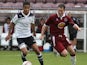Jake Nicholson of Tottenham Hotspur looks to play the ball watched by Steve Guinan of Northampton Town during a Behind Closed Doors Friendly Match between Northampton Town and Tottenham Hotspur at Sixfields Stadium on October 19, 2010