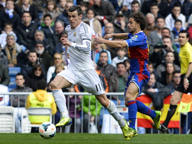 Real Madrid's Welsh striker Gareth Bale vies with Elche's midfielder Alberto Rivera during the Spanish league football match Real Madrid vs Elche at the Santiago Bernabeu stadium in Madrid on February 22, 2014