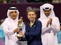 Simona Halep of Romania holds her trophy next to Qatari Minister of Finance Ali Sharif al-Emadi and president of the Qatar Tennis Federation Nasser al-Khelaifi, after winning the Qatar Open final tennis match against Angelique Kerber of Germany on Februar