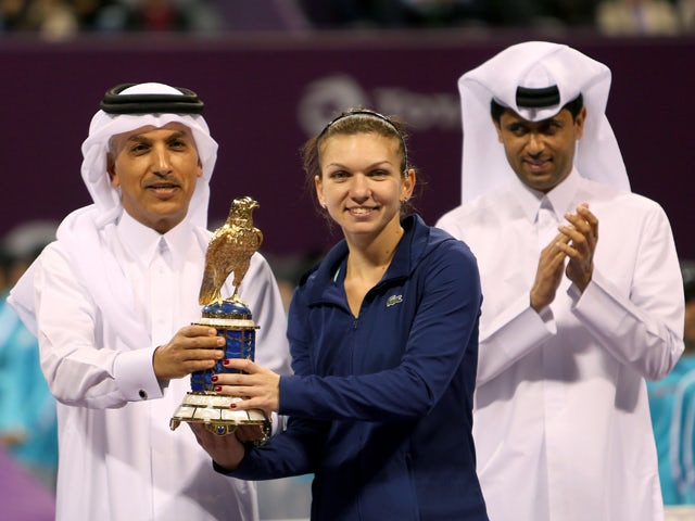 Simona Halep of Romania holds her trophy next to Qatari Minister of Finance Ali Sharif al-Emadi and president of the Qatar Tennis Federation Nasser al-Khelaifi, after winning the Qatar Open final tennis match against Angelique Kerber of Germany on Februar