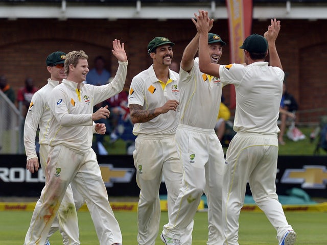 Australia team celebrates the wicket of South Africa's batsman Quinton de Kock during the second test match between South Africa and Australia at St George's Park, in Port Elizabeth on February 20, 2014