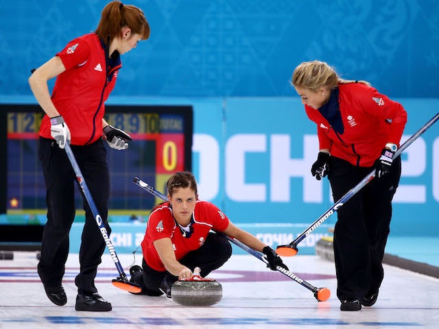 Vicki Adams of Great Britain (C) plays a stone as Claire Hamilton (L) and Anna Sloan (R) assist during the Bronze medal match against Switzerland on February 20, 2014