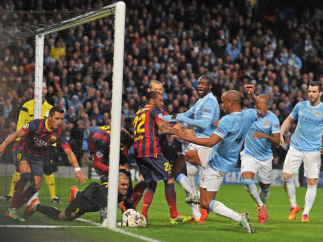 Barcelona's goalkeeper Victor Valdes makes a save near his line during the UEFA Champions League Last 16, first leg football match against Manchester City on February 18, 2014