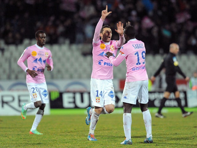 Evian's French midfielder Cedric Barbosa celebrates with teammates after scoring a goal during the French L1 football match between Evian (ETGFC) and Nantes (FCN) on February 28, 2014