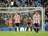 John O'Shea (2ndR) and Craig Gardner (3rdR) of Sunderland look dejected after the goal scored by Jesus Navas of Manchester City during the Capital One Cup Final on March 2, 2014