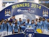 Manchester City players pose together with the League Cup after winning the final football match between Manchester City and Sunderland at Wembley Stadium in London on March 2, 2014