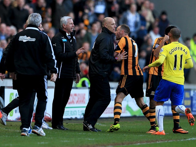Fourth official Howard Webb restrains David Meyler of Hull City after a clash with Alan Pardew manager of Newcastle United during the Barclays Premier League match between Hull City and Newcastle United at KC Stadium on March 1, 2014