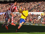 Stoke City's English forward Peter Crouch shoots wide as Arsenal's German defender Per Mertesacker tries to defend during the English Premier League football match between Stoke City and Arsenal at the Britannia Stadium in Stoke-on-Trent on March 1, 2014