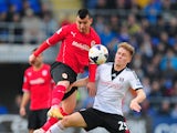 Cardiff City player Gary Medel challenges Cauley Woodrow of Fulham during the Barclays Premier league match between Cardiff City and Fulham at Cardiff City Stadium on March 8, 2014 