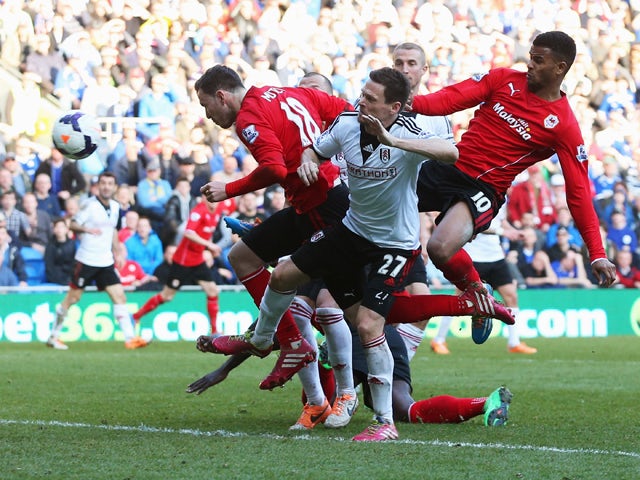 Sascha Riether of Fulham scores an own goal for Cardiff City's third as he is challenged by Jordon Mutch and Fraizer Campbell of Cardiff City (10) during the Barclays Premier League match between Cardiff City and Fulham at Cardiff City Stadium on March 8,