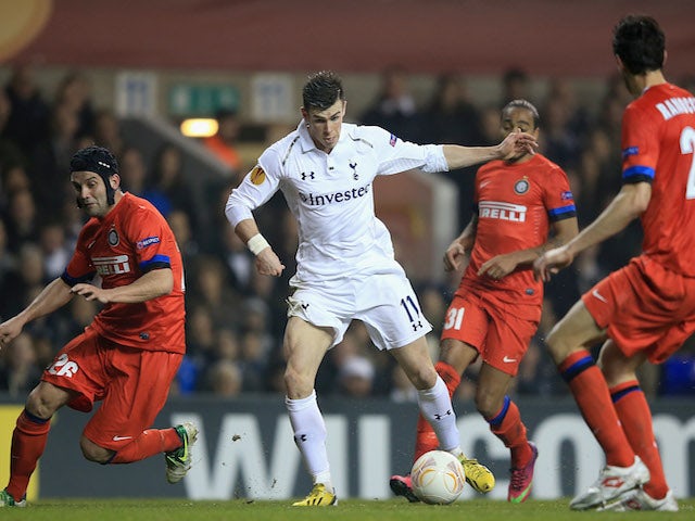 Gareth Bale of Tottenham Hotspur runs with the ball as Cristian Chivu of FC Internazionale Milano (L) closes him down during the UEFA Europa League match on March 7, 2013