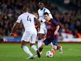 Lionel Messi of Barcelona is challenged by Vincent Kompany of Manchester City during the UEFA Champions League Round of 16, second leg match between FC Barcelona and Manchester City at Camp Nou on March 12, 2014 