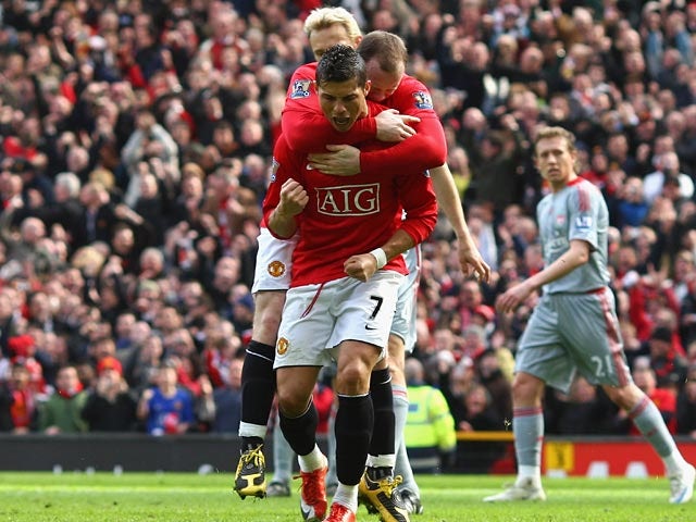 Manchester United's Cristiano Ronaldo celebrates with teammates after scoring the opening goal against Liverpool during their Premier League match on March 14, 2009