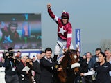 Davy Russell on Tiger Roll celebrates winning the JCB Triumph Hurdle during the Cheltenham Festival at Cheltenham Racecourse on March 14, 2014