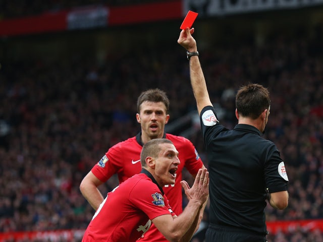 Nemanja Vidic of Manchester United is shown a red card by Referee Mark Clattenburg during the Barclays Premier League match between Manchester United and Liverpool at Old Trafford on March 16, 2014
