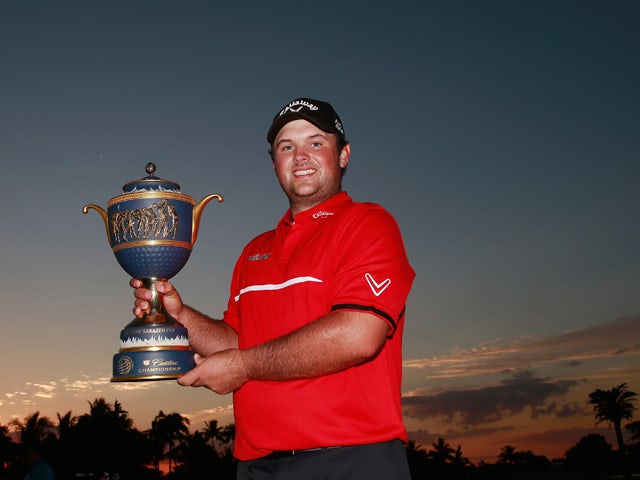 Patrick Reed celebrates with the Gene Sarazen Cup after his one-stroke victory during the final round of the World Golf Championships-Cadillac Championship at Trump National Doral on March 9, 2014