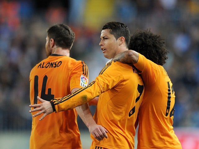 Cristiano Ronaldo of Real Madrid celebrates with Xabi Alonso and Marcelo after scoring Real's opening goal during the La Liga match between Malaga and Real Madrid at La Rosaleda Stadium on March 15, 2014