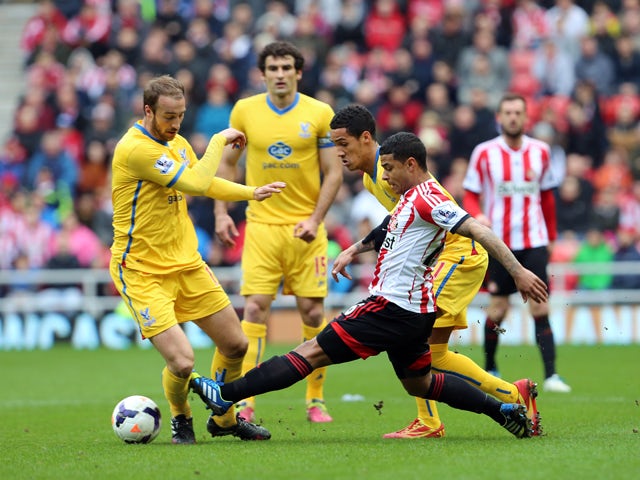 Liam Bridcutt of Sunderland clears the ball ahead of Thomas Ince of Crystal Palace during the Barclays Premier League match between Sunderland and Crystal Palace at The Stadium of Light on March 15, 2014