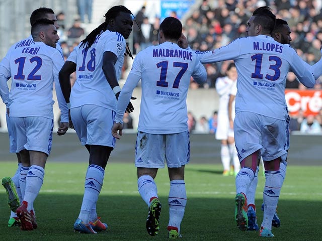 Lyon's Bafetimbi Gomis celebrates with teammates after scoring the opening goal against Guingamp in the Ligue 1 match on March 23, 2014