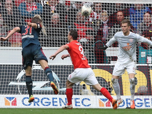 Bayern Munich's midfielder Bastian Schweinsteiger (L) heads the ball to score 0-1 during the German first division Bundesliga football match against FSV Mainz 05 on March 22, 2014