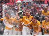 Ian Miller of Cambridge United lifts the trophy as his team celebrate during the FA Carlsberg Trophy Final 2014 at Wembley Stadium on March 23, 2014 